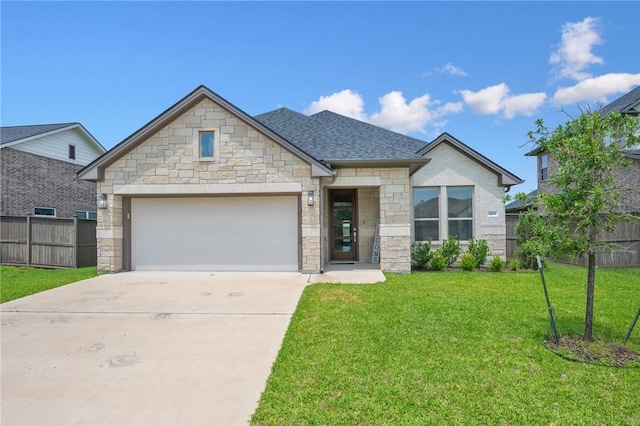 view of front of property featuring fence, a front lawn, stone siding, a garage, and driveway