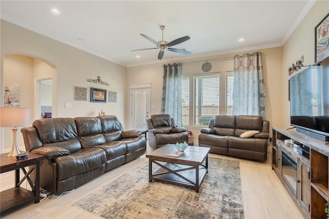 living room featuring a ceiling fan, arched walkways, recessed lighting, and ornamental molding