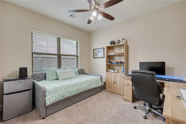 bedroom featuring freestanding refrigerator, a ceiling fan, visible vents, and light carpet