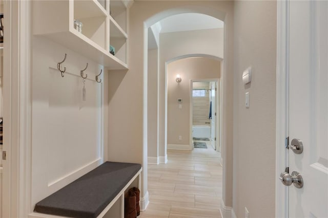 mudroom with baseboards and arched walkways