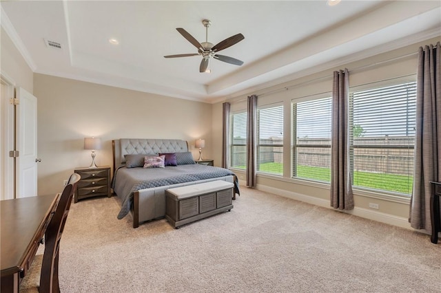 bedroom with visible vents, crown molding, light colored carpet, a raised ceiling, and a ceiling fan