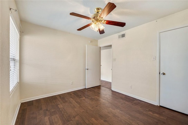 unfurnished bedroom with multiple windows, wood finished floors, visible vents, and baseboards