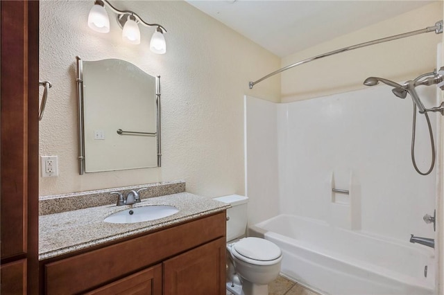 bathroom with a textured wall, tile patterned flooring, toilet, vanity, and shower / washtub combination