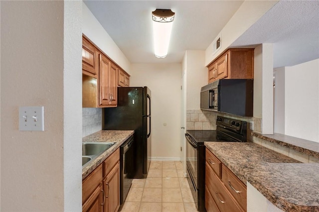 kitchen featuring black appliances, backsplash, a sink, and brown cabinetry