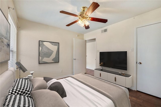 bedroom with ceiling fan, visible vents, and wood finished floors