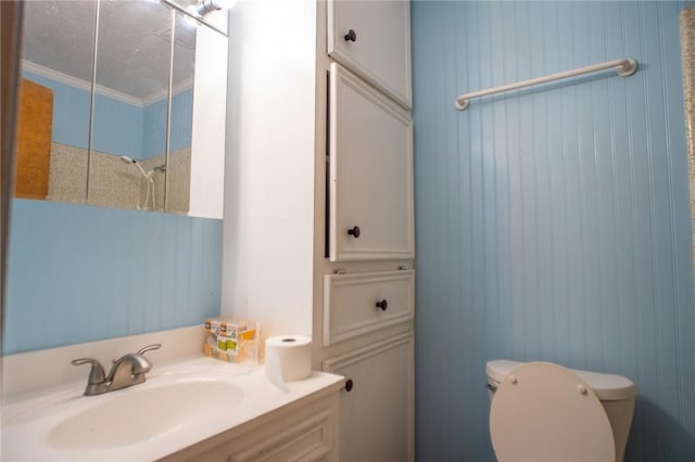 bathroom with vanity, crown molding, and toilet