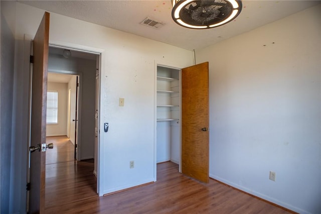 unfurnished bedroom featuring dark hardwood / wood-style flooring and a closet