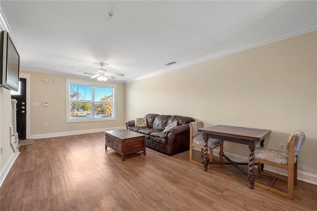 living room with crown molding, hardwood / wood-style floors, and ceiling fan