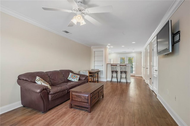 living room with ceiling fan, light hardwood / wood-style floors, and ornamental molding