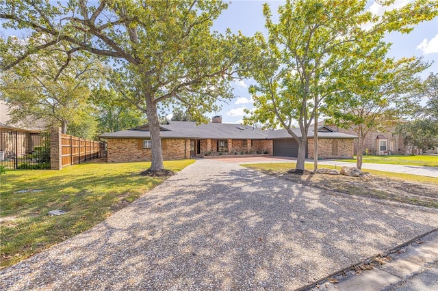 ranch-style house featuring a garage and a front yard