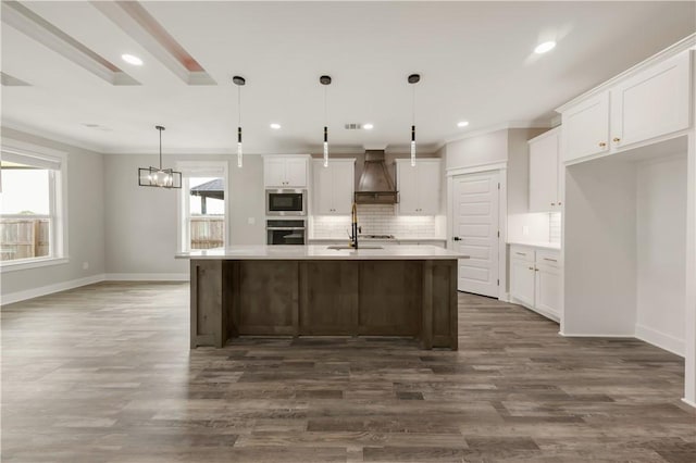 2908 Goldberg Dr, Bryan, TX 77808 - kitchen featuring stainless steel appliances, custom range hood, baseboards, tasteful backsplash, and white cabinetry