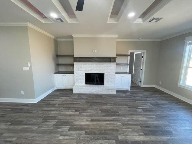 unfurnished living room with dark hardwood / wood-style flooring, a brick fireplace, crown molding, and ceiling fan