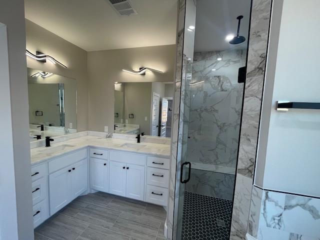 bathroom featuring vanity and a shower with shower door