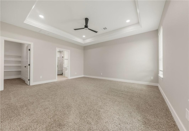 2908 Goldberg Dr, Bryan, TX 77808 - unfurnished bedroom with a tray ceiling, a spacious closet, light carpet, recessed lighting, and baseboards