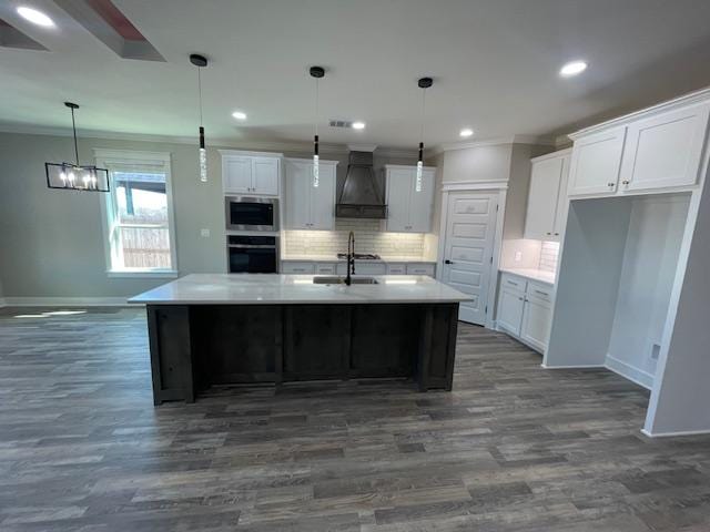 kitchen with white cabinetry, oven, and custom range hood