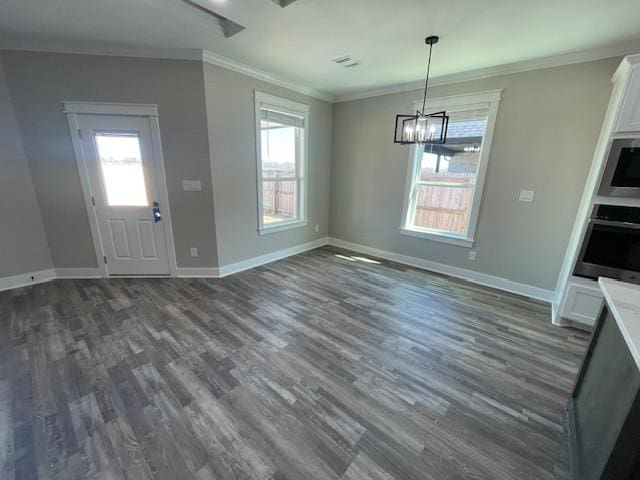 unfurnished dining area with ornamental molding, an inviting chandelier, and dark hardwood / wood-style flooring