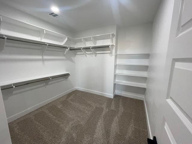 spacious closet featuring dark carpet