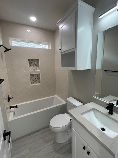 full bathroom featuring vanity, toilet, and tiled shower / bath