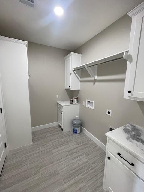 laundry room with cabinets, hookup for a washing machine, and hookup for an electric dryer