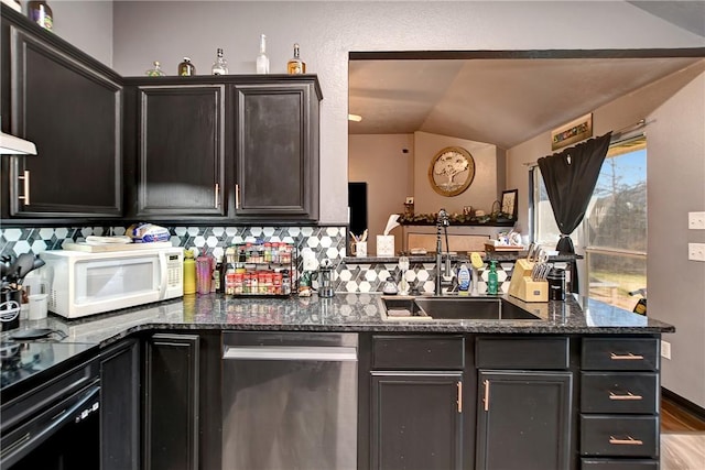 kitchen featuring dishwasher, sink, light hardwood / wood-style flooring, dark stone countertops, and tasteful backsplash