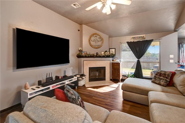 living room with a tile fireplace, ceiling fan, hardwood / wood-style floors, and lofted ceiling