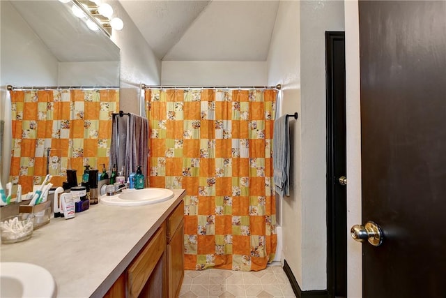 bathroom with tile patterned floors, vanity, a shower with curtain, and vaulted ceiling