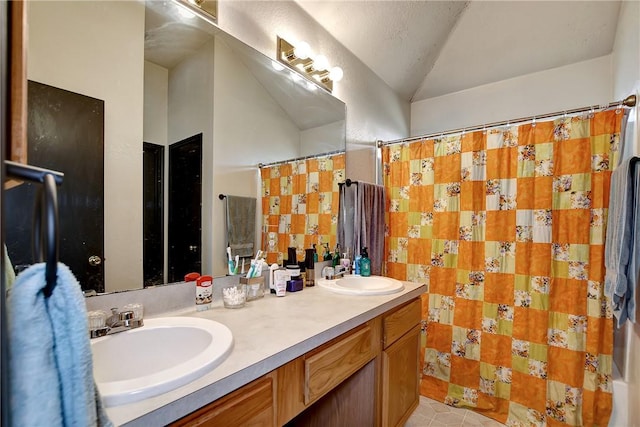 bathroom featuring tile patterned flooring, vanity, and vaulted ceiling