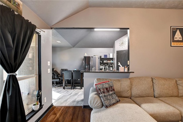 living room with indoor bar, wood-type flooring, and vaulted ceiling