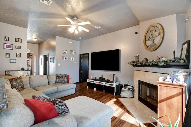 living room with a fireplace, ceiling fan, and hardwood / wood-style floors