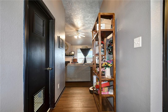 hallway with wood-type flooring and a textured ceiling