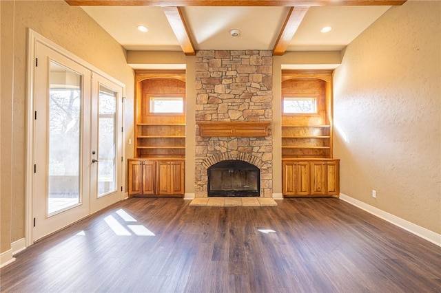 unfurnished living room with beam ceiling, dark wood-style floors, baseboards, and french doors