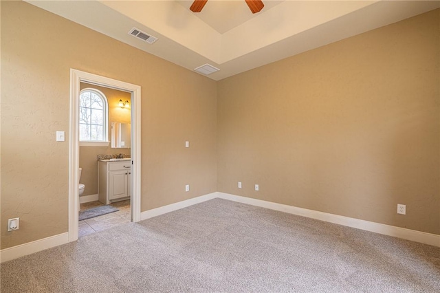 spare room featuring light carpet, visible vents, baseboards, and ceiling fan