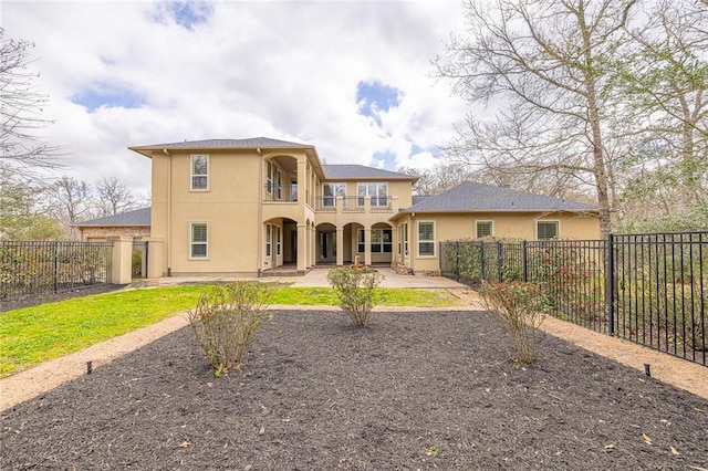 back of property featuring a patio area, a balcony, a fenced backyard, and stucco siding