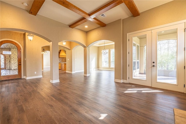 interior space with dark wood finished floors, french doors, arched walkways, and baseboards