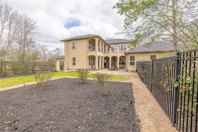 back of house featuring stucco siding, a fenced backyard, and a patio area