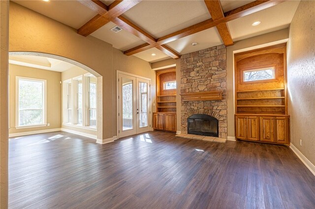 unfurnished living room with beamed ceiling, built in shelves, coffered ceiling, dark wood finished floors, and baseboards