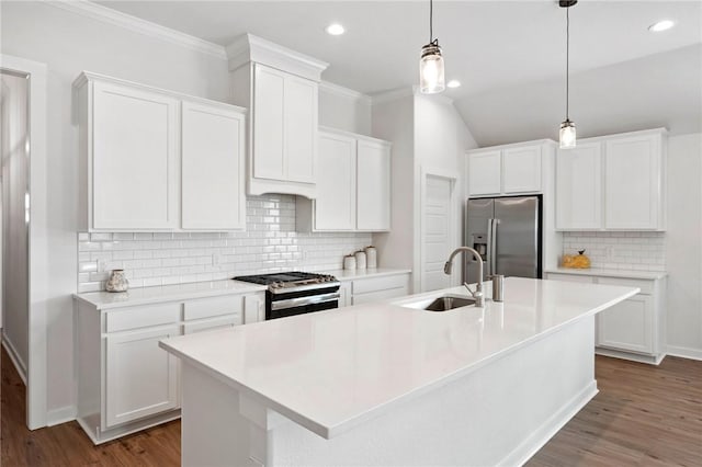 kitchen featuring an island with sink, sink, white cabinets, hanging light fixtures, and stainless steel appliances