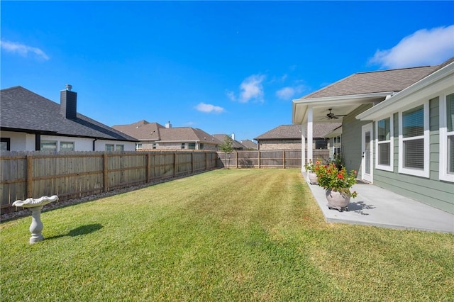 view of yard with ceiling fan and a patio