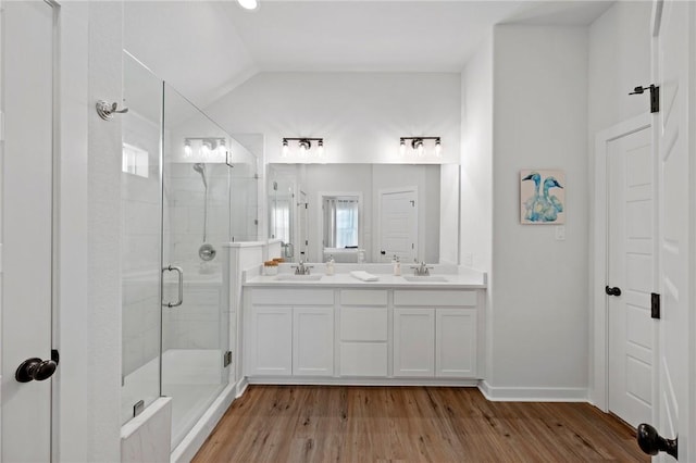 bathroom with hardwood / wood-style flooring, lofted ceiling, a shower with shower door, and vanity