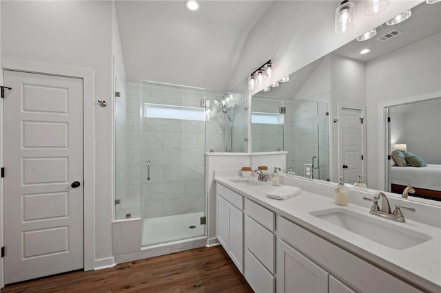 bathroom featuring wood-type flooring, lofted ceiling, an enclosed shower, and vanity