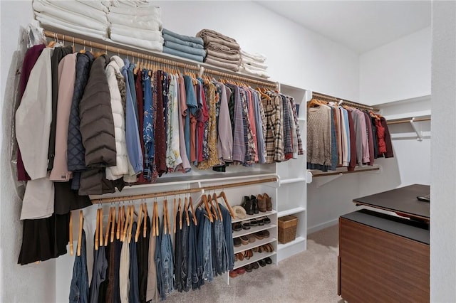 walk in closet featuring light colored carpet