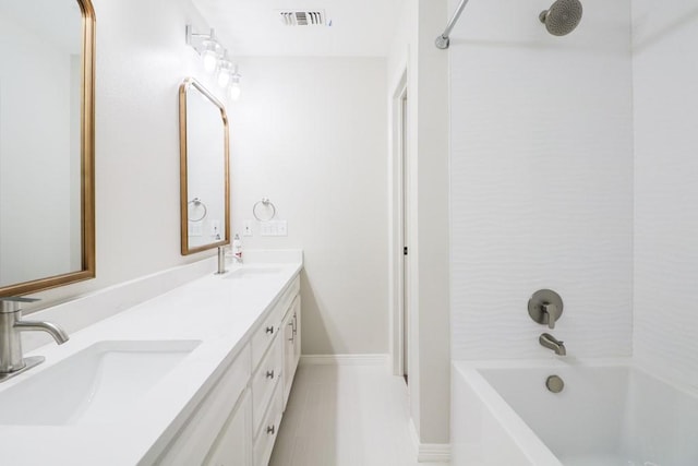 bathroom featuring vanity and tiled shower / bath