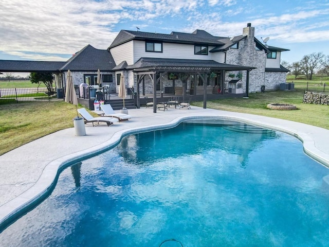 view of pool featuring central AC unit, a patio area, a fire pit, and a lawn