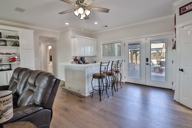 kitchen featuring a kitchen breakfast bar, dark hardwood / wood-style floors, white cabinetry, and french doors