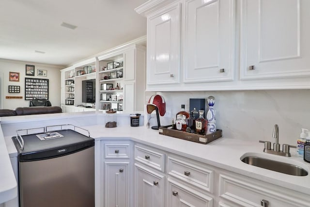 kitchen featuring white cabinets, stainless steel fridge, and sink