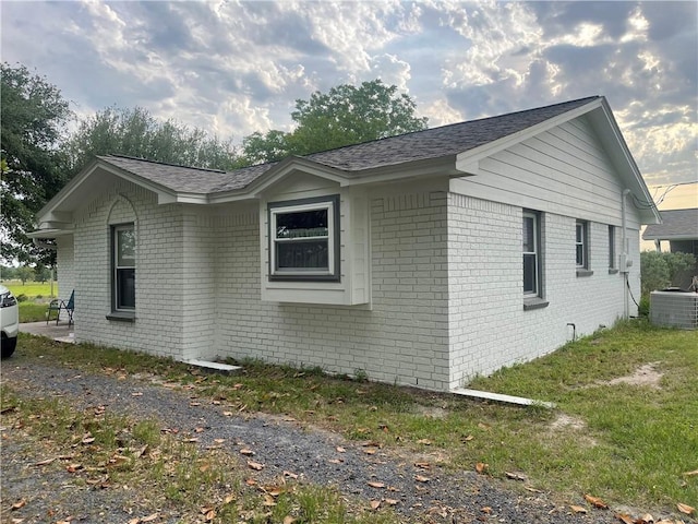 16659 Hwy 90 N, Bedias, TX 77831 - view of side of property with brick siding, cooling unit, and a shingled roof
