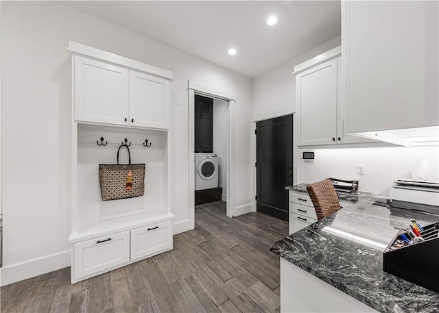 kitchen with recessed lighting, wood finished floors, white cabinetry, dark stone countertops, and washer / dryer