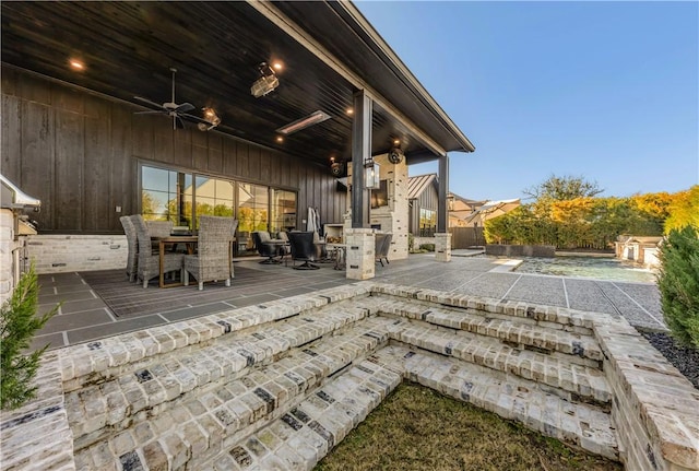 view of patio with outdoor dining area and ceiling fan