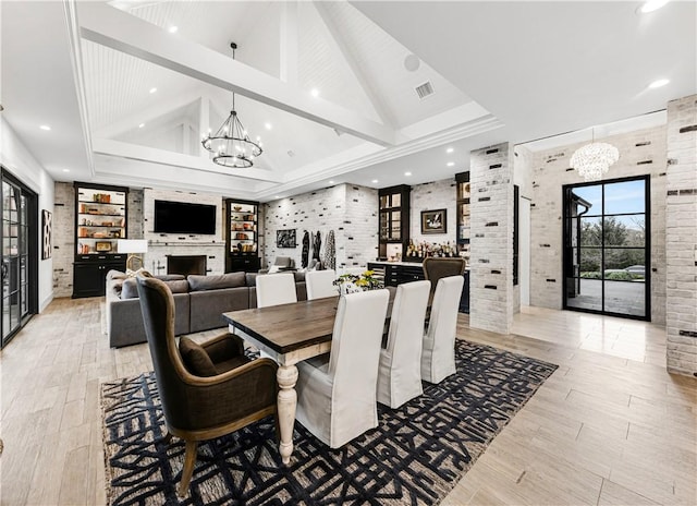 dining area with a chandelier, visible vents, high vaulted ceiling, and brick wall