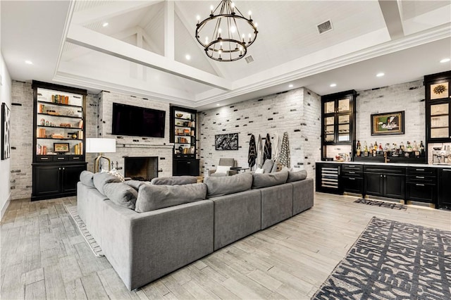 living room featuring visible vents, a bar, light wood-style floors, a fireplace, and high vaulted ceiling